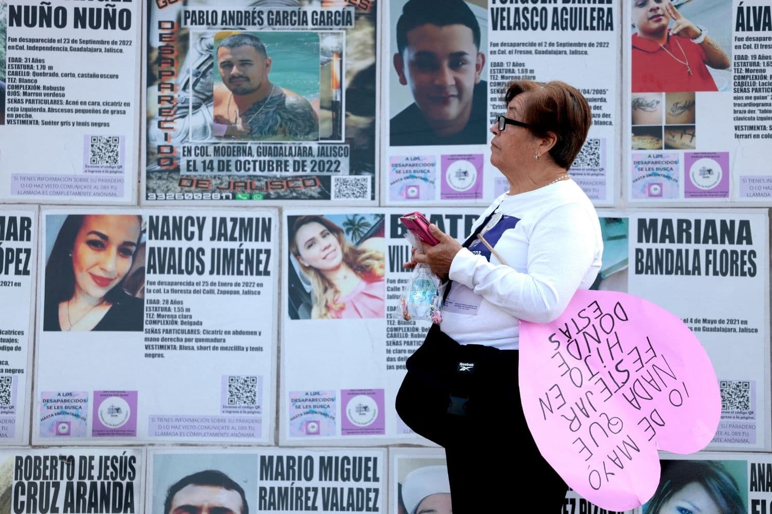 Una madre que busca a su hijo desaparecido sostiene un cartel en el que se lee: "10 de mayo, nada que celebrar, hijo, ¿dónde estás?", mientras al fondo se ven carteles de personas desaparecidas durante una manifestación celebrada el Día de la Madre en Guadalajara, en el estado de Jalisco, México, el 10 de mayo de 2026. (ULISES RUIZ / AFP vía Getty Images)