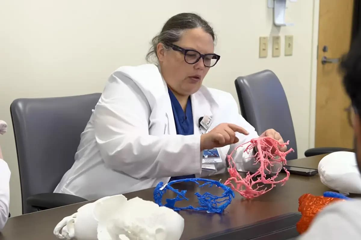<em>La Dra. Joanna Kemp examina una réplica impresa en 3D de alta fidelidad del sistema venoso interconectado de los gemelos antes de la trascendental cirugía. (Hospital Infantil SSM Health Cardinal Glennon).</em>