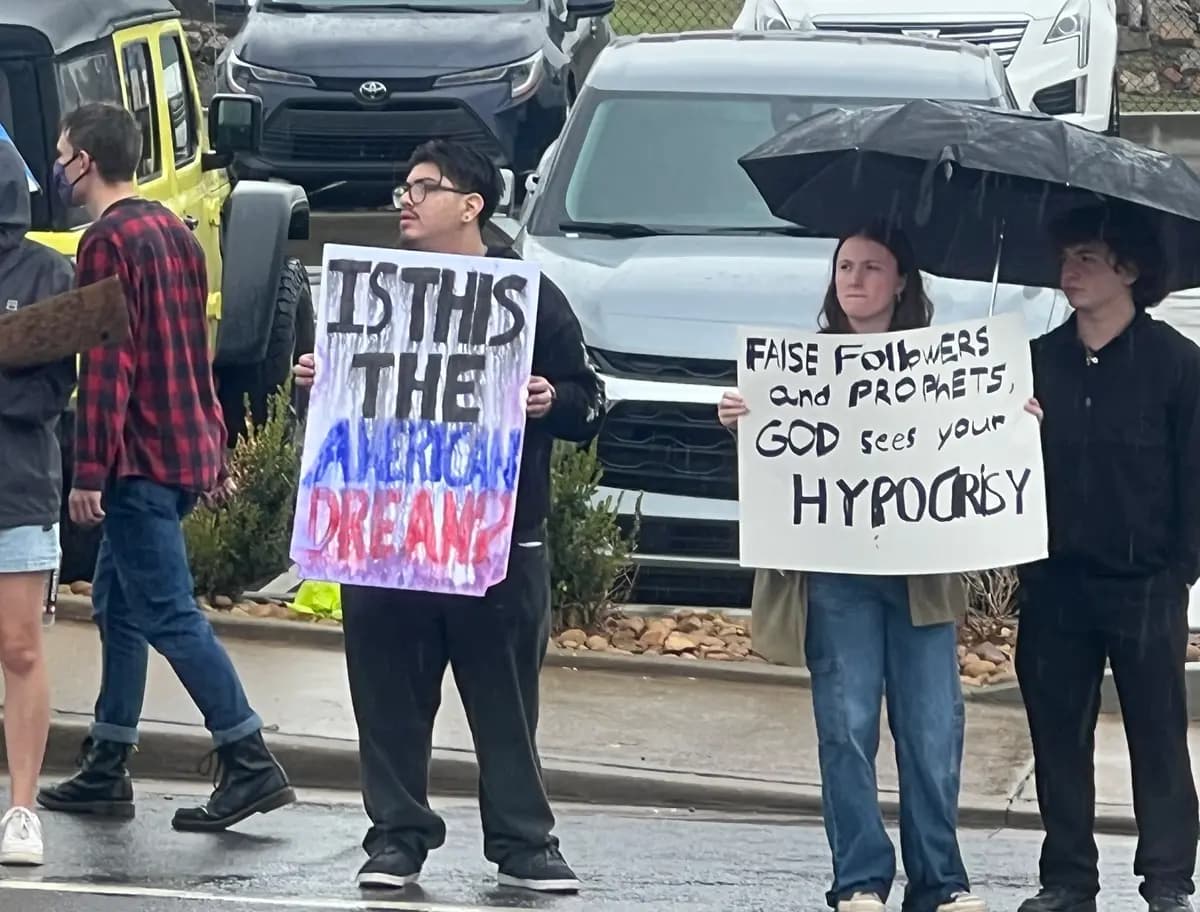 Alrededor de tres docenas de manifestantes contrarios a Trump se situaron al otro lado de la calle, frente al lugar donde los asistentes al mitin hacían cola para ver al presidente Donald Trump en el F&M Bank Arena de Clarksville, Tennessee, el 10 de octubre de 2026. (Jacki Thrapp/The Epoch Times)