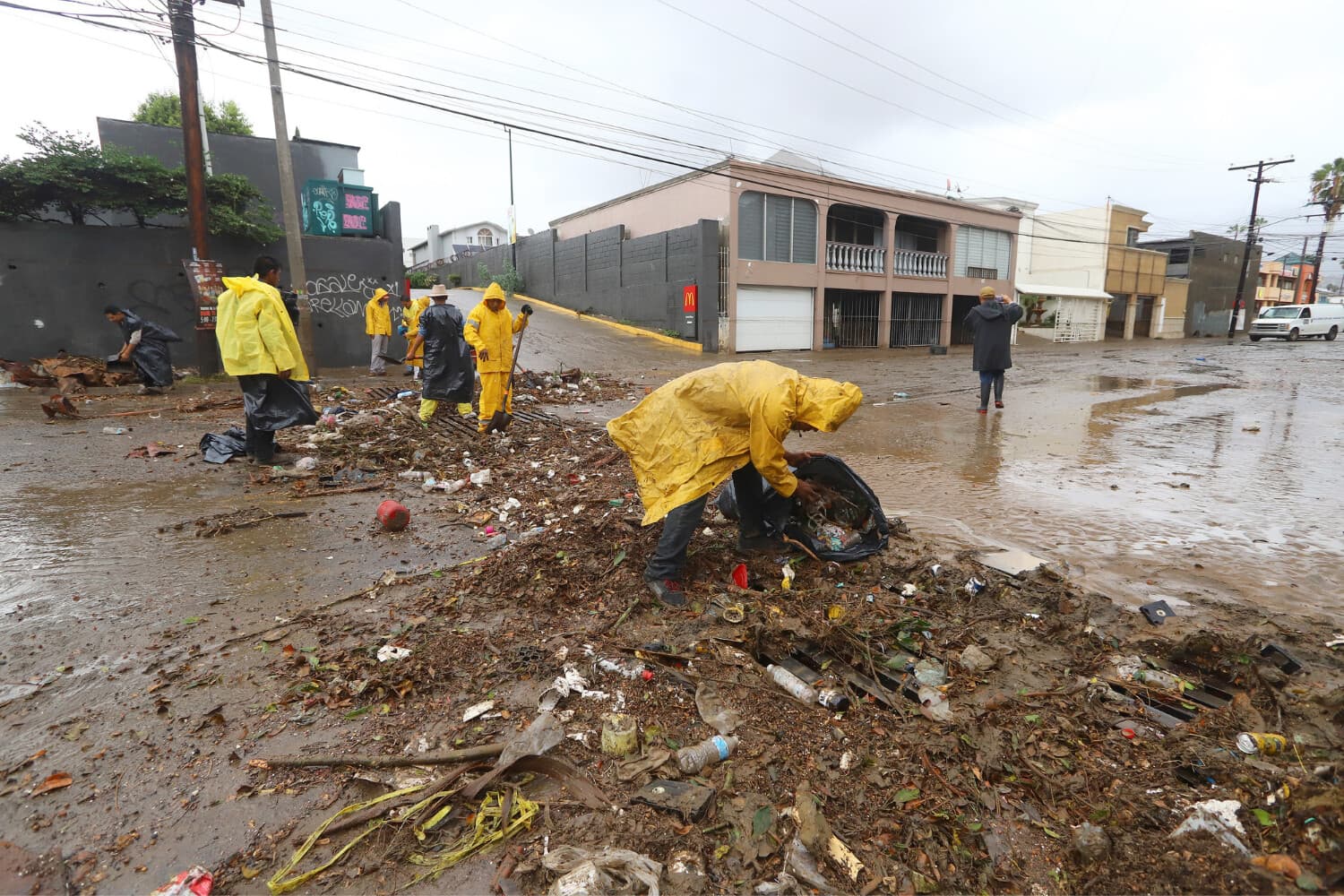 Fotografía que muestra personas recogiendo escombros y basura este domingo en el municipio de Ensenada en Baja California, México. (EFE/Alejandro Zepeda)
