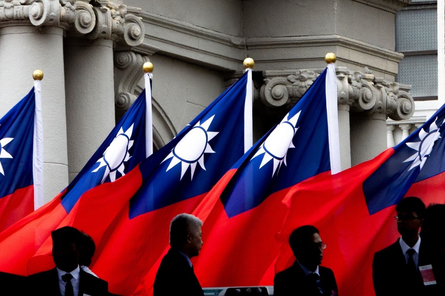 Una fila de banderas nacionales de la República de China (Taiwán) ondea frente a un histórico edificio de piedra, con funcionarios de traje en primer plano, durante las celebraciones del Día Nacional el 10 de octubre de 2026 en Taipéi, Taiwán. (Cheng Chia Huang/Getty Images)