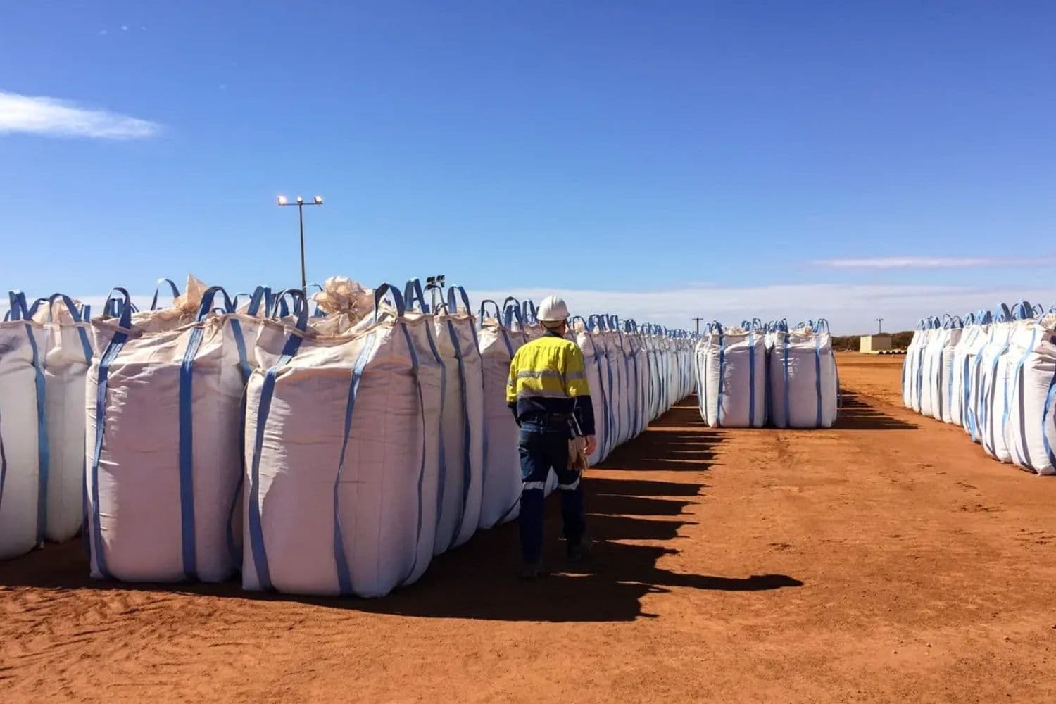 Un trabajador de Lynas Corp pasa junto a sacos de concentrado de tierras raras que esperan ser enviados a Malasia en Mount Weld, al noreste de Perth, Australia, el 23 de agosto de 2019. (Melanie Burton/Reuters)