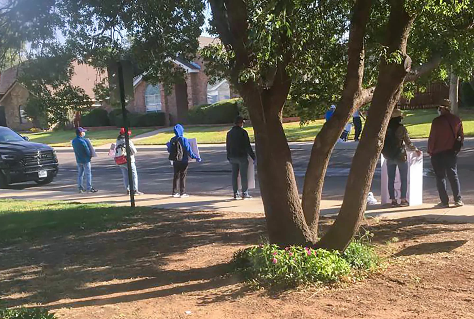 <em>En otoño de 2020, manifestantes se congregan frente a la casa del pastor Bob Fu en Midland, Texas. Fu, cuya organización, ChinaAid, aboga por la libertad religiosa en China, ha sufrido durante años campañas de acoso, incluyendo la llegada de grandes multitudes en autobús a su domicilio, acciones que él cree fueron coordinadas por el gobierno chino. (Bob Fu vía AP).</em>