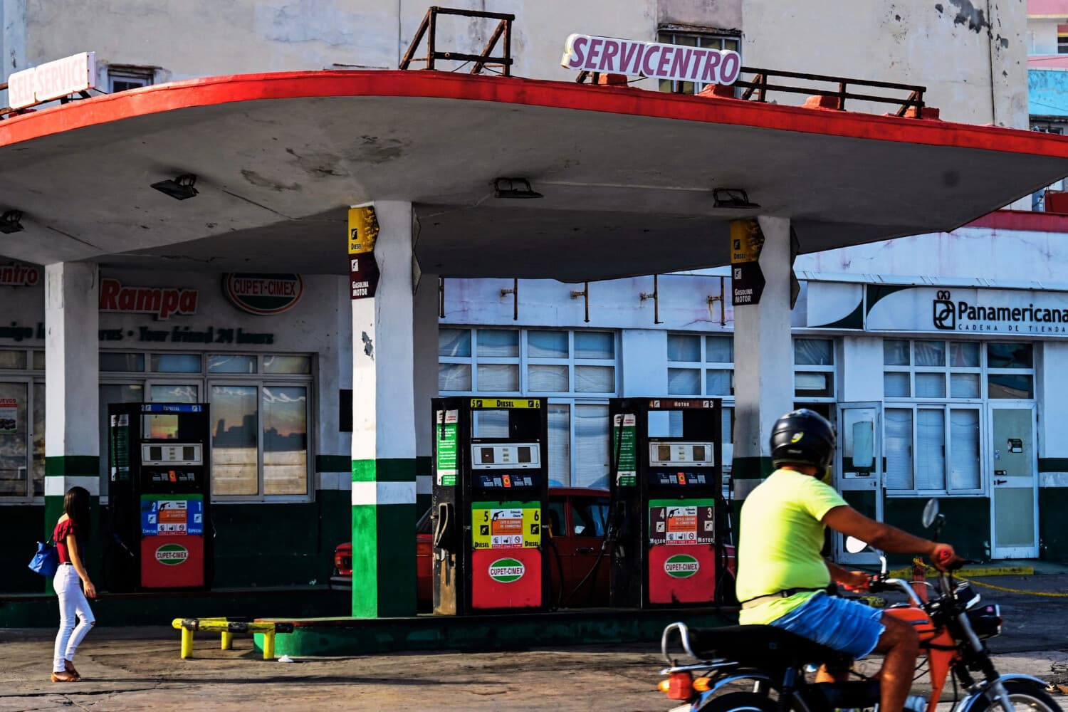Un hombre que va en moto pasa junto a una gasolinera vacía en La Habana el 24 de abril de 2023. (YAMIL LAGE/AFP vía Getty Images)