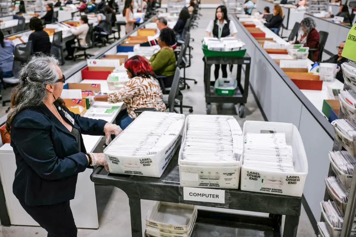 <em>Un funcionario electoral traslada las boletas de voto por correo para su posterior recuento en el Centro de Procesamiento de Votos del Condado de Los Ángeles durante las elecciones primarias estatales de California en City of Industry, California, el 2 de junio de 2026. (Patrick T. Fallon/AFP vía Getty Images).</em>
