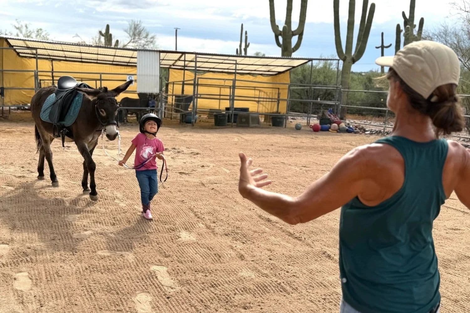Sophie Rainer (derecha), instructora de equinoterapia y fundadora de Donkeys of the Heart en Cave Creek, Arizona, guía a Dylan, de 4 años, durante su clase de equitación el 24 de septiembre de 2026. (Allan Stein/The Epoch Times)