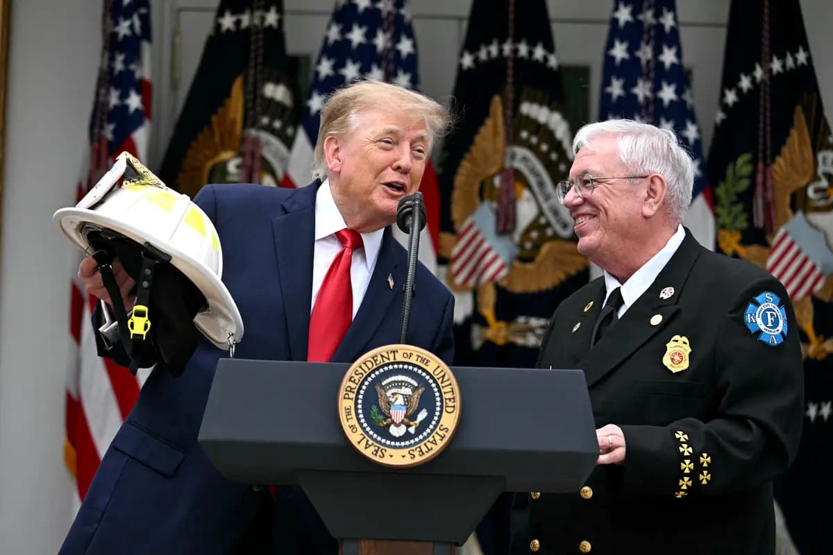 El presidente Donald Trump (izquierda) habla mientras Steve Hirsch, presidente del Consejo Nacional de Bomberos Voluntarios (NVFC), lo observa en el Jardín de las Rosas de la Casa Blanca, el 15 de octubre de 2026. (Jim Watson/AFP vía Getty Images).