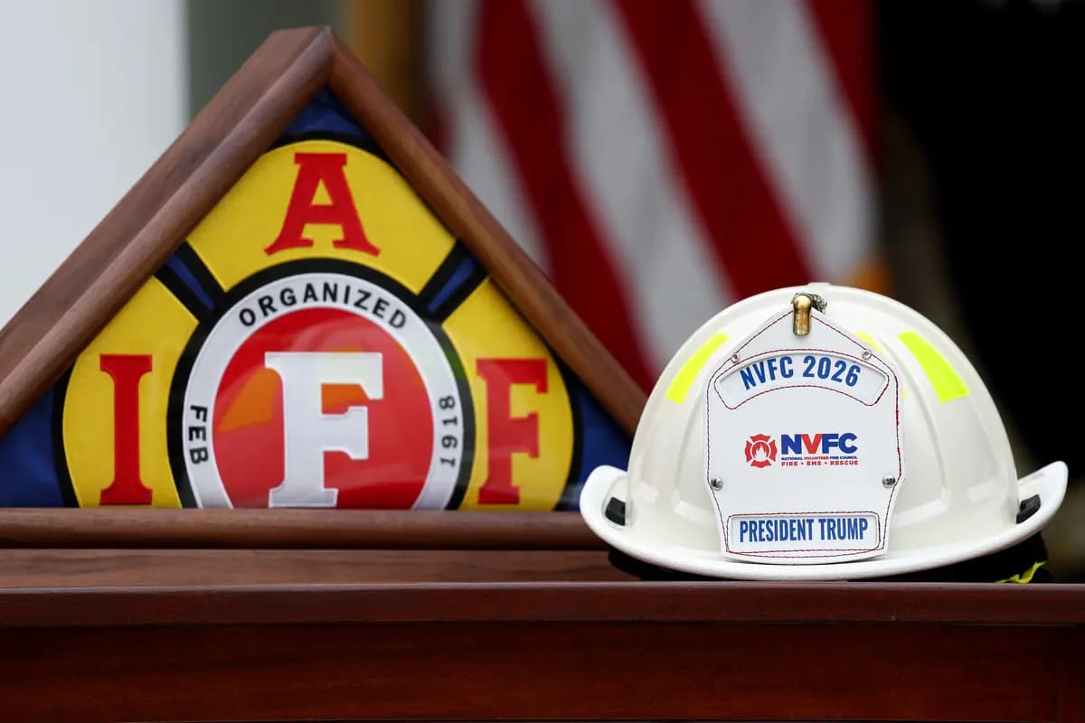 Se exhiben una bandera de la Asociación Internacional de Bomberos y un casco del Consejo Nacional de Bomberos Voluntarios antes de un almuerzo en el Jardín de las Rosas de la Casa Blanca el 15 de octubre de 2026. El presidente Trump organizó el almuerzo para honrar a los socorristas de todo el país. (Kevin Dietsch/Getty Images).