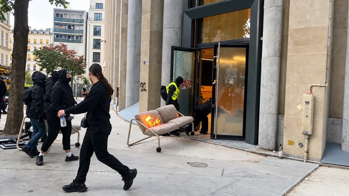 <em>Manifestantes de extrema izquierda enmascarados arrastran un sofá en llamas hasta las oficinas de la empresa francesa de tecnología financiera Qonto en un intento de prender fuego al edificio durante las violentas manifestaciones en París el 17 de octubre de 2026. (Etienne Fauchaire/The Epoch Times).</em>