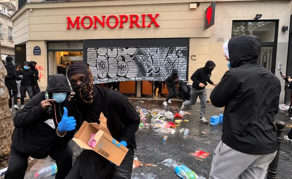 <em>Manifestantes enmascarados saquean un supermercado Monoprix en el Boulevard Saint-Denis de París, llevándose mercancía que queda esparcida fuera del establecimiento dañado durante las violentas protestas del 17 de octubre de 2026. (Etienne Fauchaire/The Epoch Times).</em>