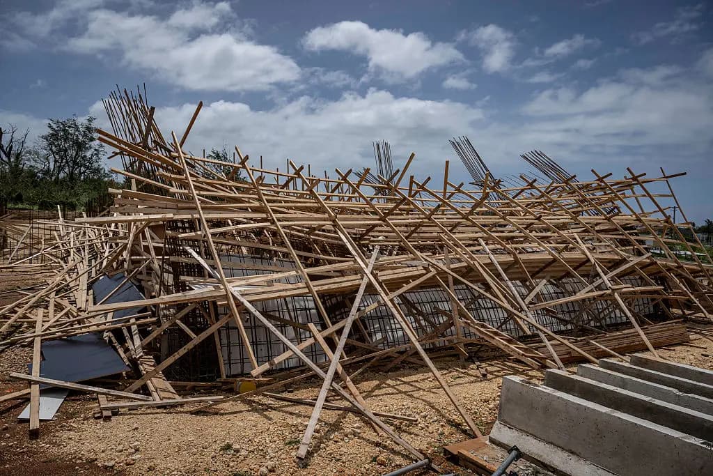 Un edificio en construcción yace derruido tras los fuertes vientos y las intensas lluvias provocadas por el supertifón Bavi en Guam el 7 de julio de 2026. (Yuichi Yanazaki/AFP vía Getty Images).