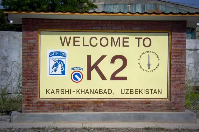 (Arriba) Mapa de Karshi-Khanabad, o K2, una antigua base militar soviética en Uzbekistán que serviría como punto de partida para futuras incursiones militares estadounidenses en Afganistán. (Abajo) Cartel de "Bienvenido a K2" en la base aérea de Karshi-Khanabad. (Ilustración de The Epoch Times, dominio público).
