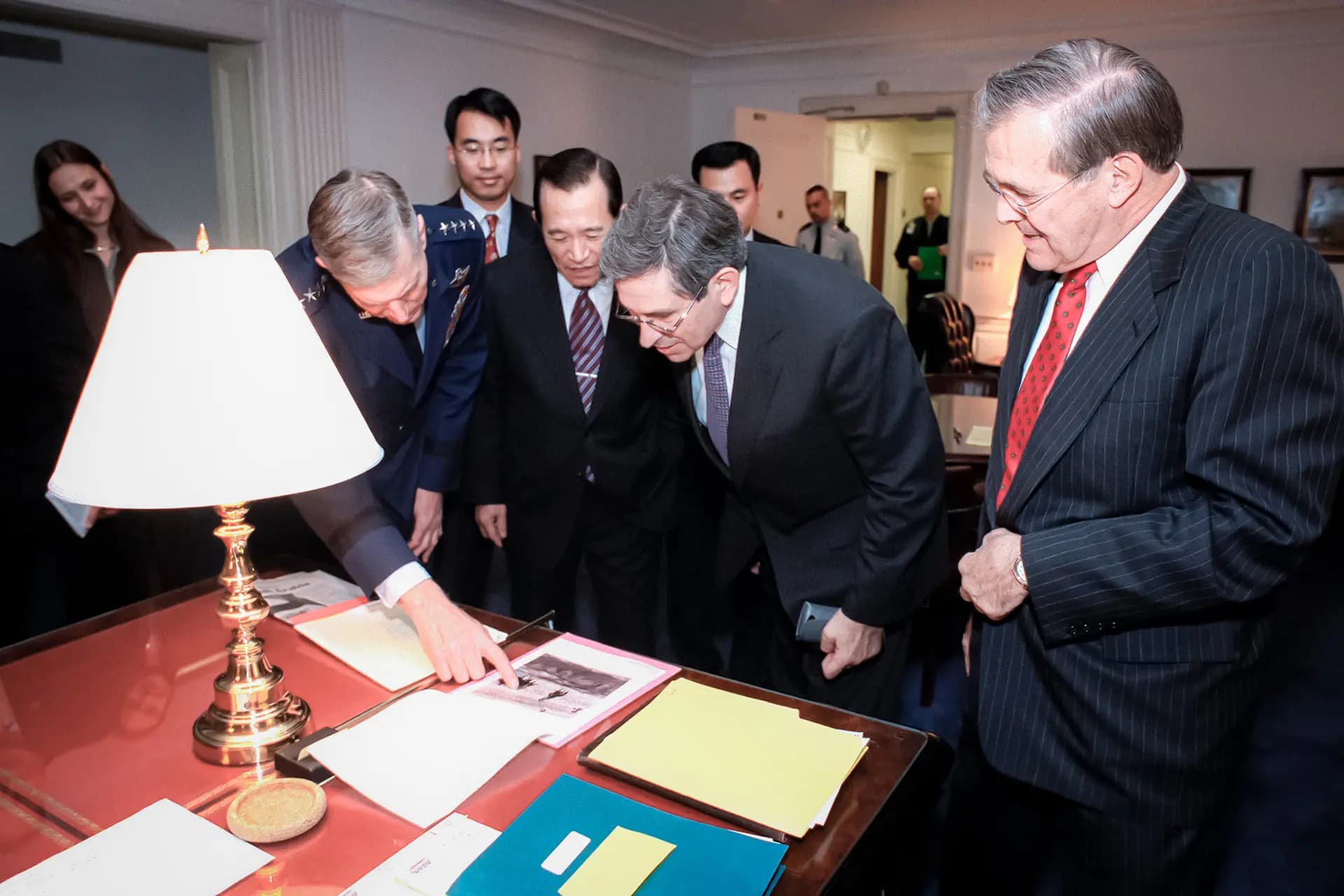 El secretario de Defensa Donald H. Rumsfeld (derecha) muestra a sus invitados una fotografía de tropas de operaciones especiales estadounidenses montando a caballo en Afganistán, en su oficina del Pentágono en Arlington, Virginia, el 15 de noviembre de 2001. (Fotografía del Departamento de Defensa por RD Ward).