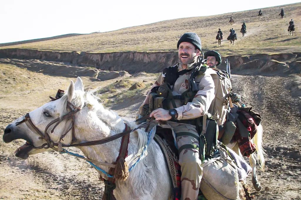 El sargento mayor de la Fuerza Aérea de los Estados Unidos, Bart Decker, controlador de combate asignado al Destacamento Operacional Charlie 53 de las Fuerzas Especiales del Ejército, cabalga a caballo junto a otros miembros del personal estadounidense y fuerzas aliadas afganas en Afganistán en noviembre de 2001. (Cortesía del sargento mayor retirado Christopher Spence).