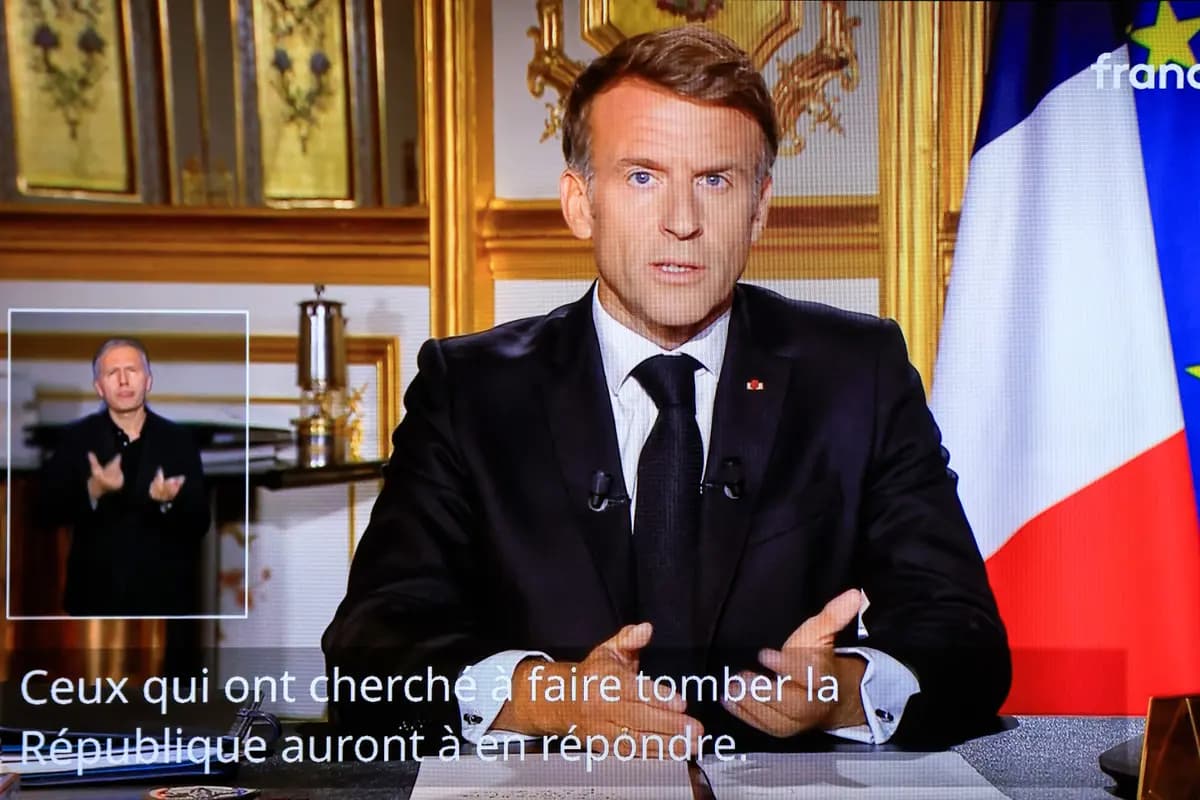 <em>Un monitor de televisión transmite un discurso del presidente francés Emmanuel Macron desde el Palacio del Elíseo, con subtítulos que dicen: "Quienes intentaron derrocar la República tendrán que responder por ello", al día siguiente de los disturbios y saqueos ocurridos paralelamente a las protestas a nivel nacional, en París, el 18 de octubre de 2026. (Ludovic Marin/AFP vía Getty Images).</em>