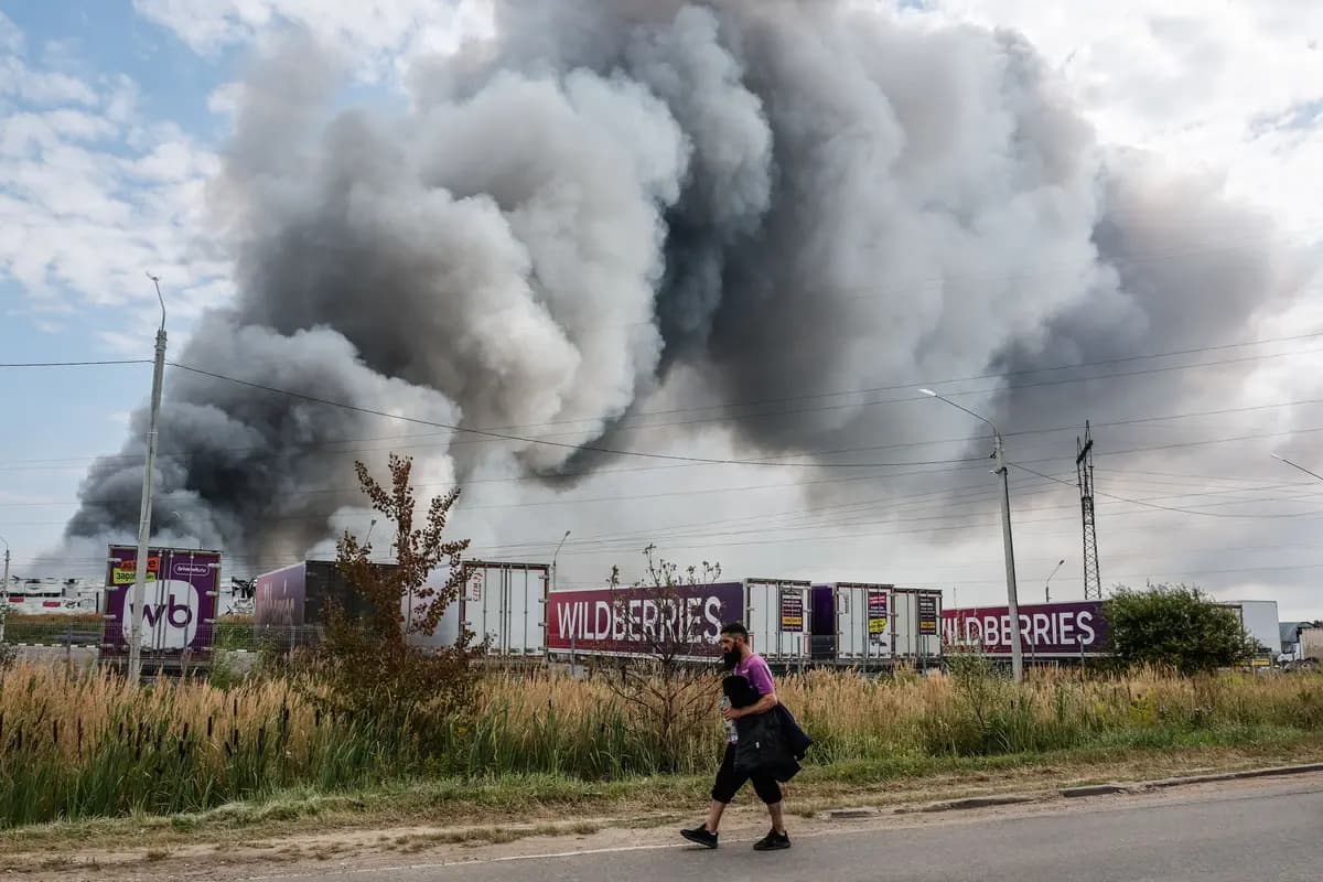 <em>Un empleado de Wildberries pasa junto a una columna de humo que se eleva durante un incendio en el complejo logístico de la empresa rusa de comercio electrónico cerca de Podolsk, en las afueras de Moscú, el 16 de agosto de 2026. (Tatyana Makeyeva/AFP vía Getty Images).</em>