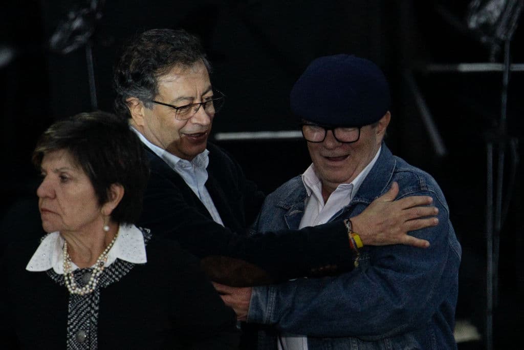 El presidente de Colombia, Gustavo Petro (izq.), saluda al excomandante en jefe de las FARC, Rodrigo Londoño, alias Timochenko, durante la octava conmemoración de la firma del acuerdo de paz econ la guerrilla de las FARC en la Plaza de Bolívar, en Bogotá, el 21 de noviembre de 2024. (ANDREA ARIZA/AFP vía Getty Images)