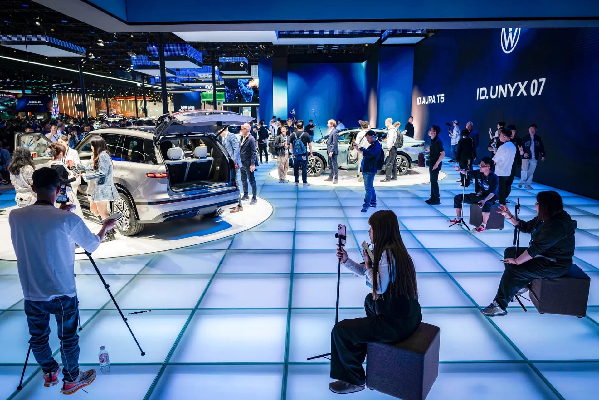 Los presentadores de transmisiones en vivo trabajan en el área de exhibición de vehículos eléctricos de Volkswagen en el Salón Internacional del Automóvil de Beijing el 24 de abril de 2026. El Grupo Volkswagen reportó una caída del 38.5 por ciento en las entregas de vehículos en China durante el tercer trimestre de 2026. (Kevin Frayer/Getty Images).