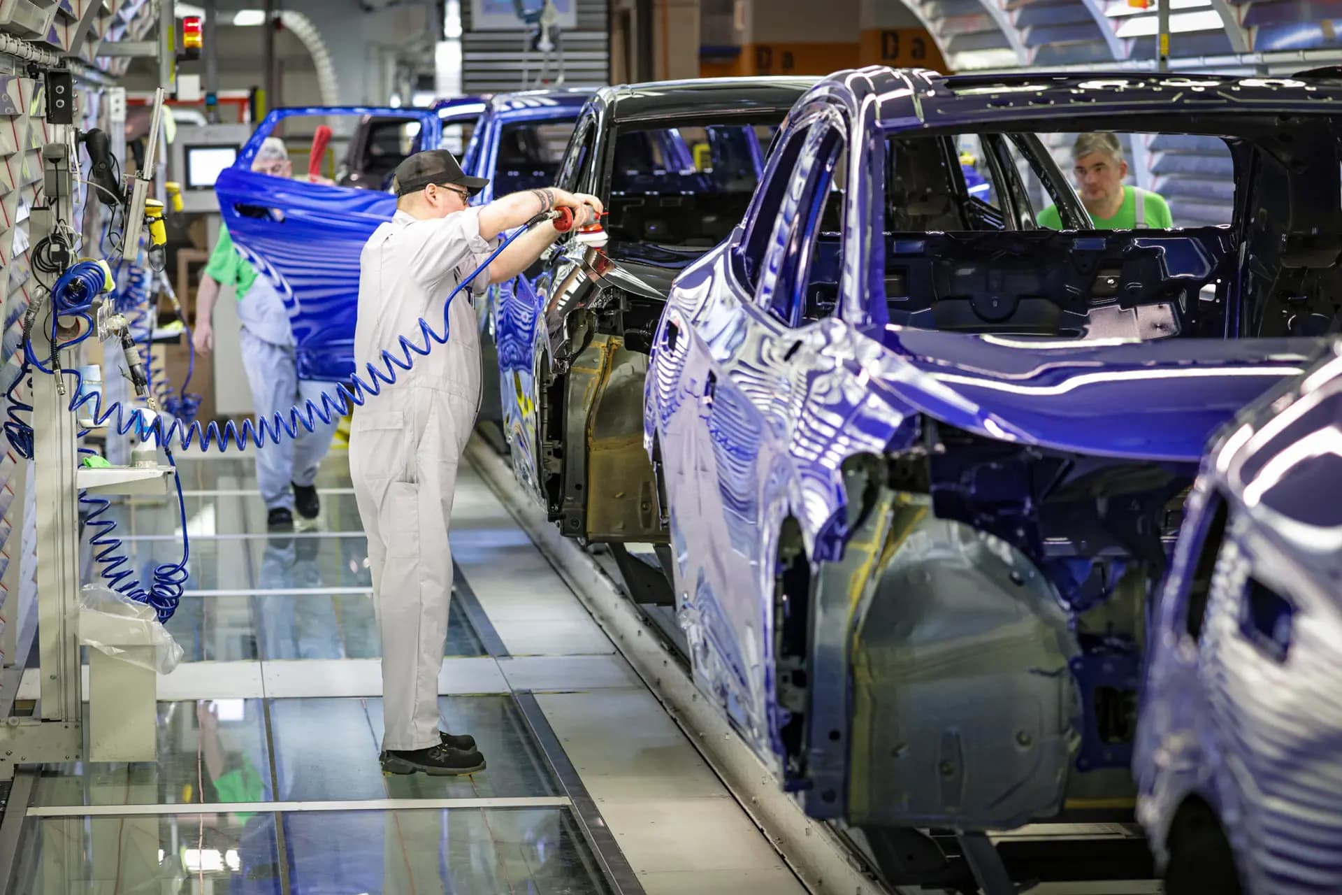 Un trabajador de la línea de ensamblaje de Volkswagen realiza revisiones finales y ajustes en autos eléctricos en el taller de pintura de la fábrica de autos eléctricos de Volkswagen en Emden, Alemania, el 24 de febrero de 2026. El plan de reestructuración de la empresa, aprobado en septiembre, tiene como objetivo recuperar los márgenes operativos y eliminar aproximadamente 50,000 puestos de trabajo. (Focke Strangmann/Getty Images).