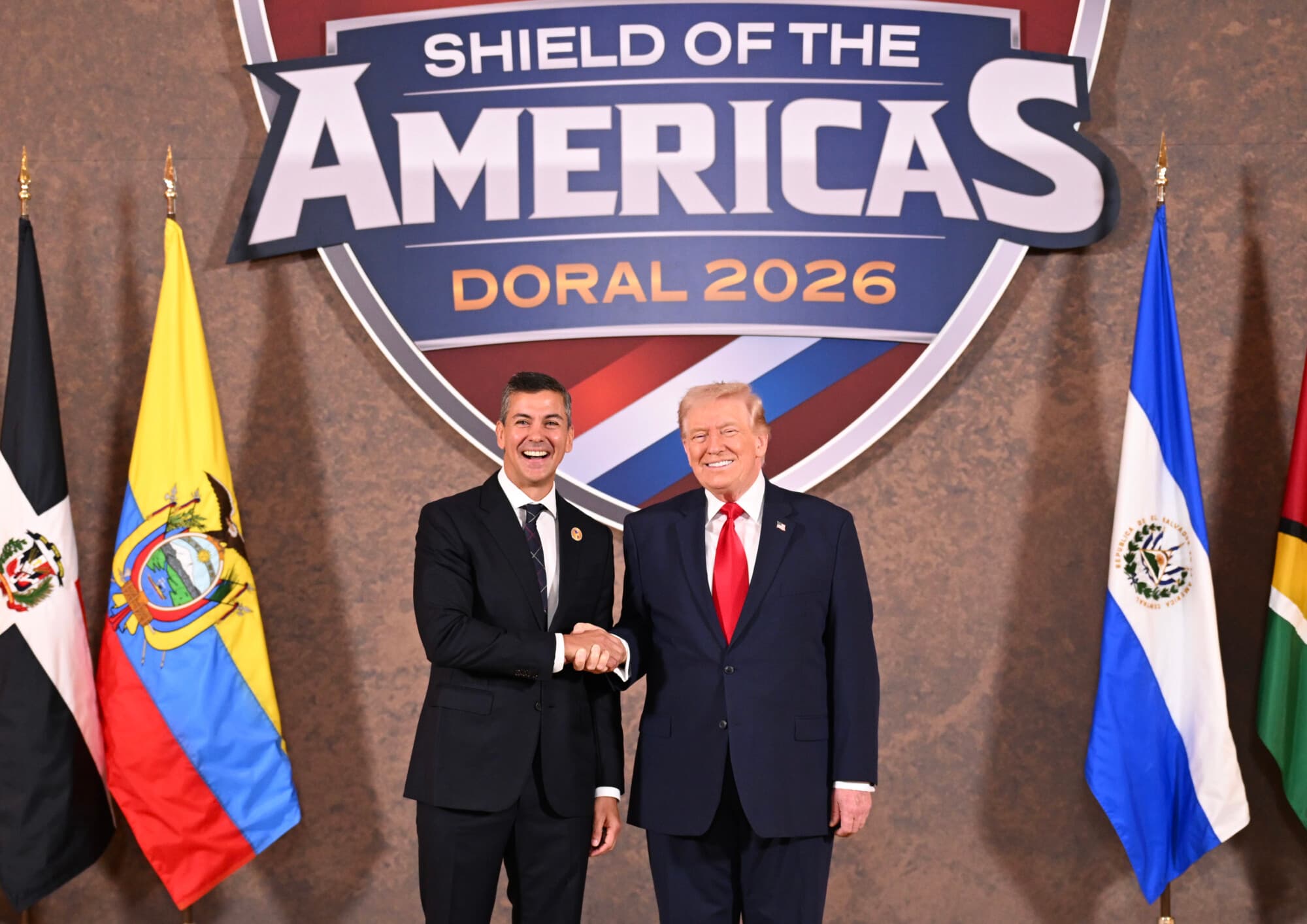 El presidente de Estados Unidos, Donald Trump, saluda a Santiago Peña, presidente de la República de Paraguay, como anfitrión de la “Cumbre El Escudo de las Américas”, una reunión con jefes de estado y funcionarios de gobierno de 12 países de las Américas en el Trump National Doral Golf Club el 7 de marzo de 2026 en Doral, Florida. (Roberto Schmidt/Getty Images)
