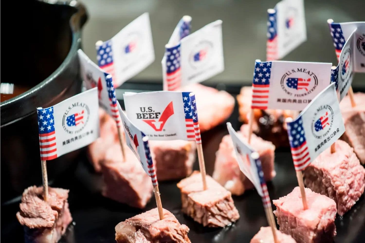 Banderas estadounidenses y marcas en muestras de carne de res estadounidense cortada durante un evento promocional en Beijing el 30 de junio de 2017. (Fred Dufour/AFP vía Getty Images)