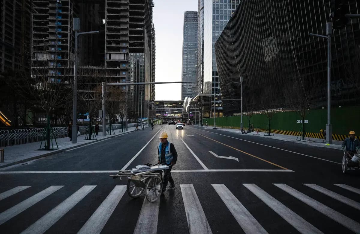 <em>Un obrero de la construcción empuja una carretilla cargada de materiales por la calle en el distrito financiero central de Beijing, China, el 29 de noviembre de 2024. (Kevin Frayer/Getty Images).</em>