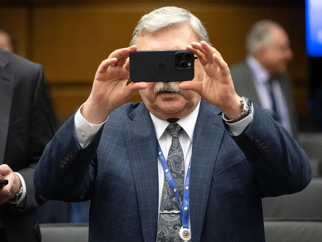 El representante permanente de la Federación Rusa ante las organizaciones internacionales en Viena, Mikhail Ulyanov, toma una foto de los periodistas mientras asiste a la reunión de la Junta de Gobernadores del Organismo Internacional de Energía Atómica (OIEA) en la sede de la agencia en Viena, Austria, el 30 de enero de 2026. (Joe Klamar/AFP vía Getty Images)