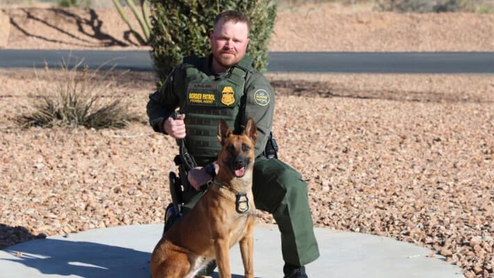 En esta foto sin fecha y de ubicación desconocida publicada por el Departamento de Seguridad Nacional, se ve al oficial de la Patrulla Fronteriza David Maland posando con un perro de servicio. (Departamento de Seguridad Nacional vía AP)