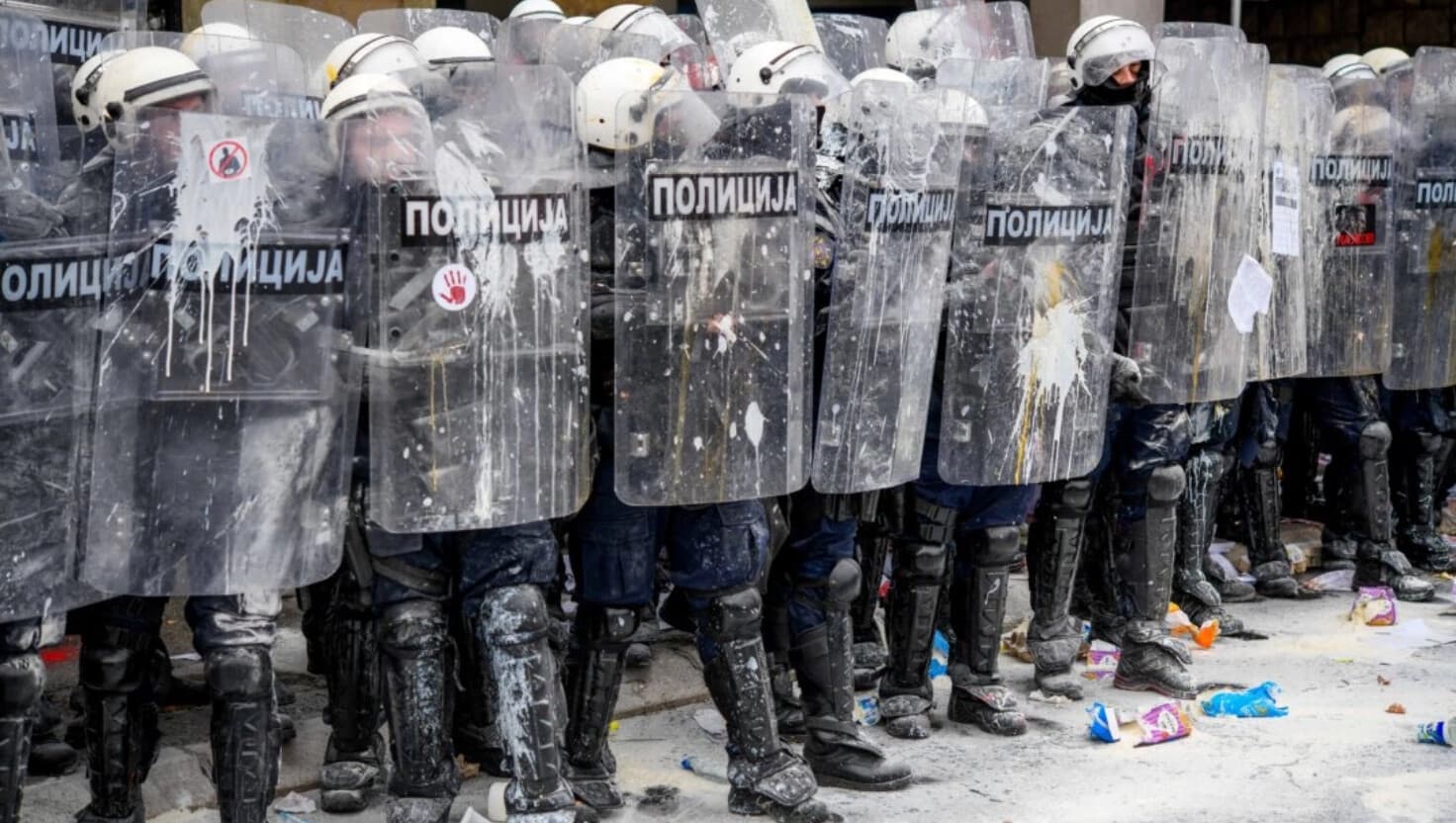 Agentes de policía serbios bloquean la entrada al ayuntamiento de Novi Sad mientras los manifestantes locales les lanzan huevos, harina y pintura durante la elección del nuevo alcalde de Novi Sad, el 24 de febrero de 2025. (Nenad Mihajlovic/AFP a través de Getty Images).