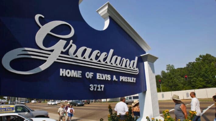 Los fans pasan por la entrada de Graceland, la casa de Elvis Presley, en Memphis, Tennessee, el 14 de agosto de 2007. (STAN HONDA/AFP a través de Getty Images)