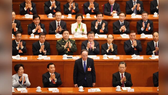 Wang Qishan (C), el recién elegido vicepresidente de China recibe aplausos tras ser elegido durante la quinta sesión plenaria de la primera sesión de la XIII Asamblea Popular Nacional (APN) en el Gran Palacio del Pueblo de Pekín el 17 de marzo de 2018. (GREG BAKER/AFP a través de Getty Images).
