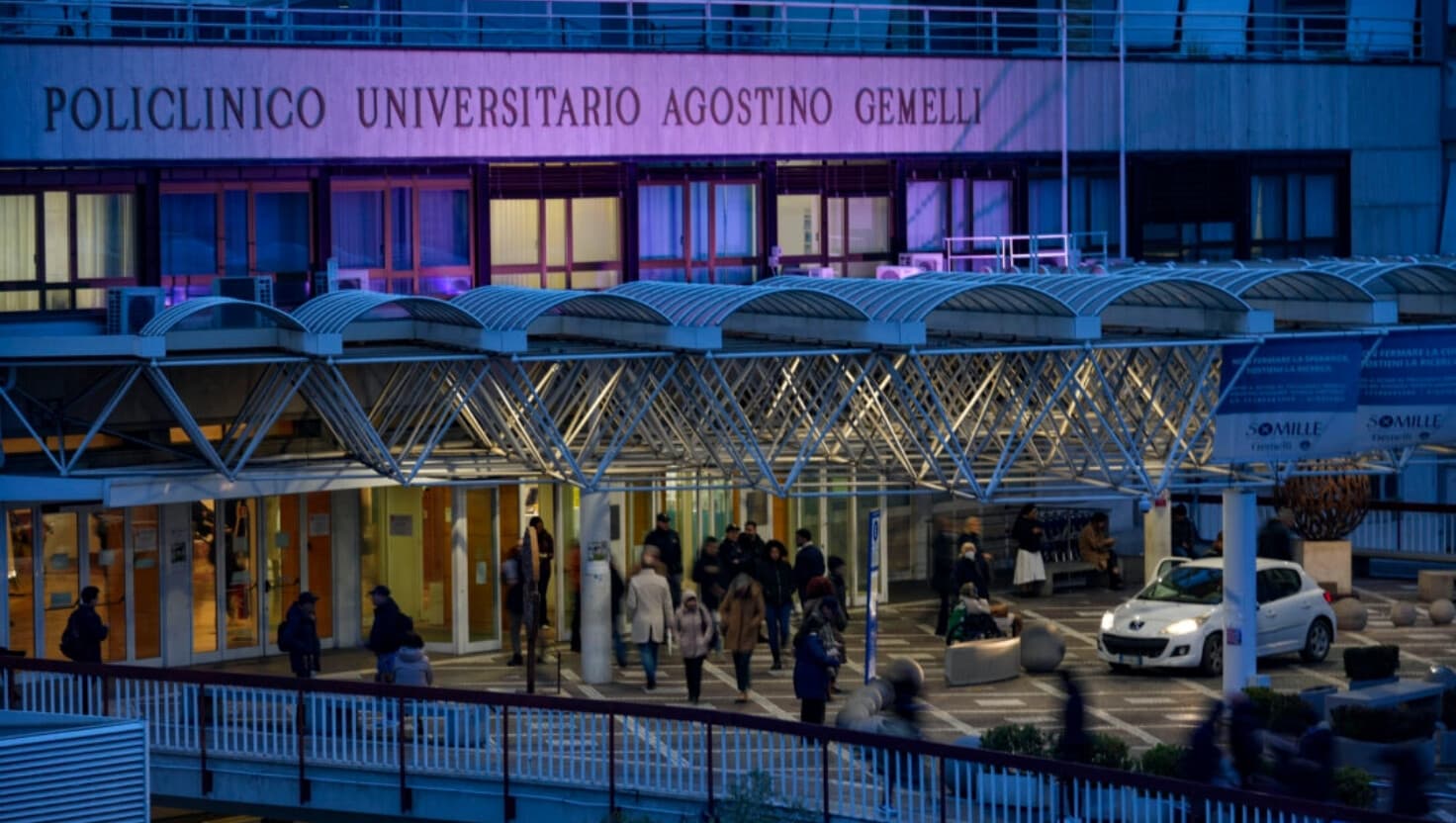 Gente caminando frente a la entrada principal del Policlínico Agostino Gemelli en Roma, miércoles 19 de febrero de 2025, donde el Pontífice está hospitalizado desde el viernes 14 de febrero. (Andrew Medichini/AP Photo).