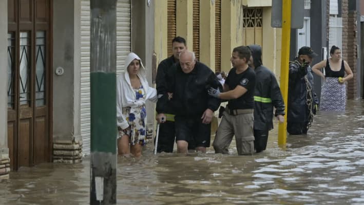 Un anciano recibe ayuda para evacuar una zona inundada después de que una poderosa tormenta azotara la ciudad de Bahía Blanca, a 600 km al sur de Buenos Aires (Argentina), el 7 de marzo de 2025. (Pablo Presti/AFP vía Getty Images)