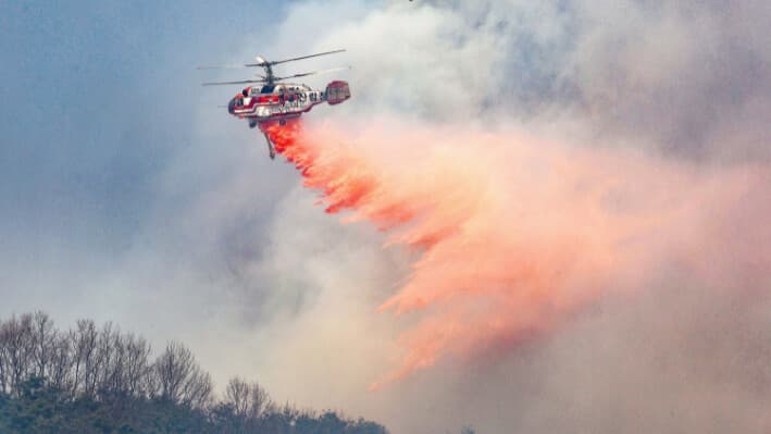Un helicóptero del Servicio Forestal de Corea vierte retardante de fuego en un incendio forestal en Uiseong, Corea del Sur, el 24 de marzo de 2025. (Yoon Gwan-shick/Yonhap vía A).