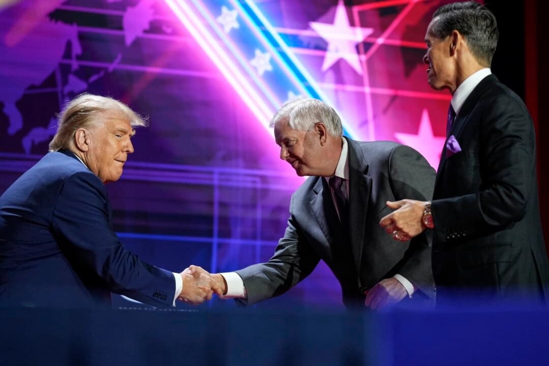 El presidente Donald Trump, estrecha la mano del senador Lindsey Graham (R-Carolina del Sur) mientras llega al escenario para hablar en la conferencia Faith and Freedom Road to Majority en el Washington Hilton en Washington el 24 de junio de 2023. (Drew Angerer/Getty Images)