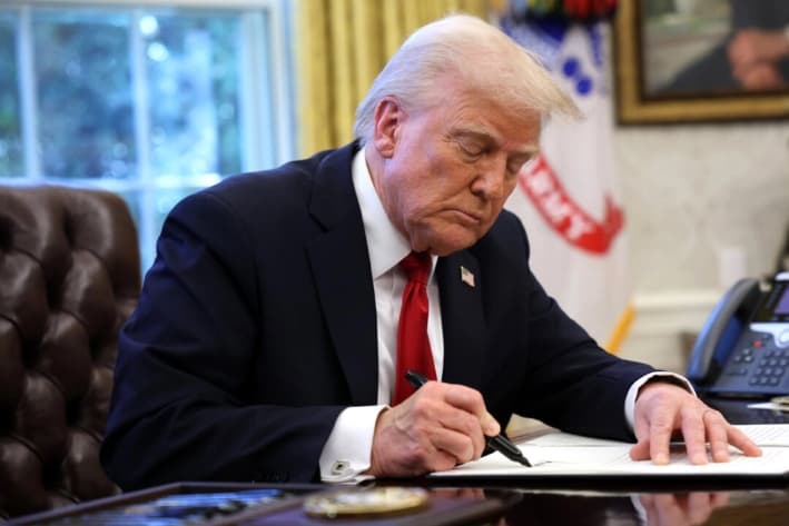 El presidente Donald Trump firma una orden ejecutiva en la Oficina Oval de la Casa Blanca, el 26 de marzo de 2025. (Win McNamee/Getty Images)