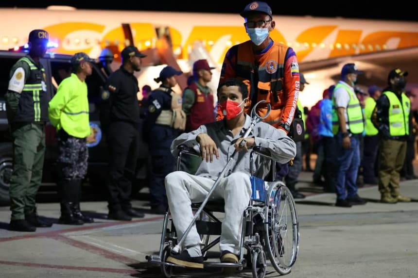 Fotografía cedida por Prensa del Ministerio de Interior, Justicia y Paz, donde se observa a un integrante de la Protección Civil de Venezuela ayudando a un migrante este viernes 28 de marzo de 2025, a su llegada al Aeropuerto Internacional Simón Bolívar, en La Guaira (Venezuela). EFE/ Prensa Ministerio Interior, Justicia y Paz
