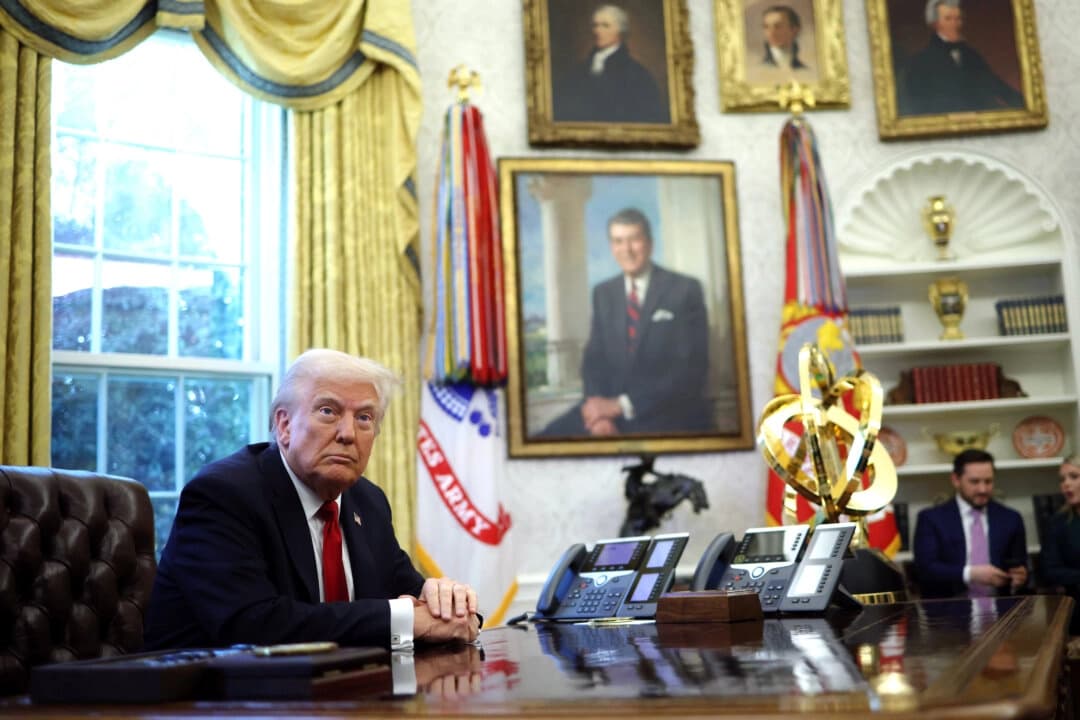 El presidente Donald Trump se prepara para firmar una orden ejecutiva en la Oficina Oval de la Casa Blanca, el 26 de marzo de 2025. (Win McNamee/Getty Images)