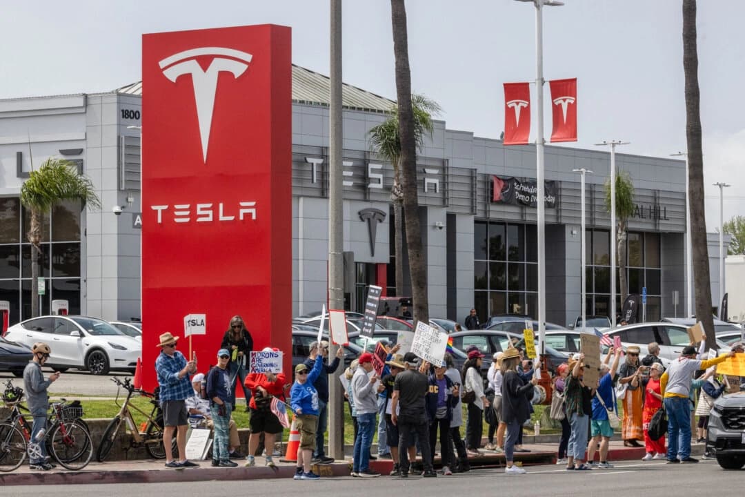Manifestantes protestan frente a una concesionaria de Tesla en Long Beach, California, el 29 de marzo de 2025. (John Fredricks/The Epoch Times)