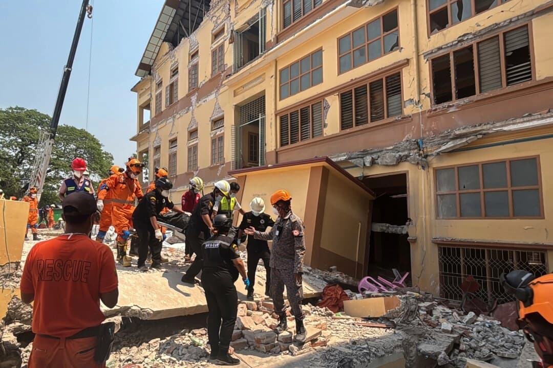 Rescatistas indios y birmanos llevan un cadáver del monasterio budista U Hla Thein que se derrumbó en el terremoto del viernes en Mandalay, Birmania, el 31 de marzo de 2025. (Foto AP)