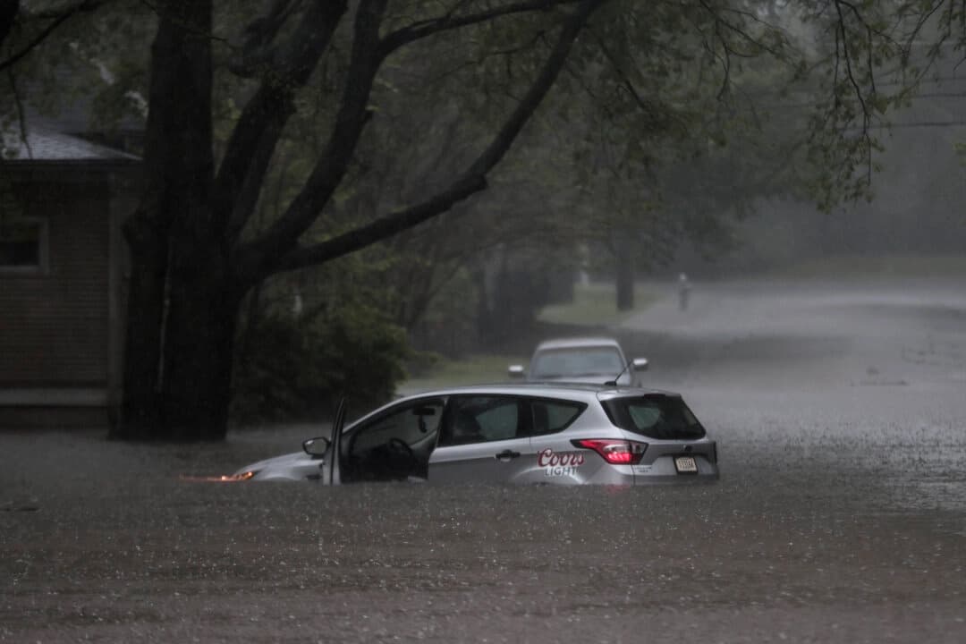 Un automóvil quedó atrapado en las aguas inundadas cerca de la esquina de Cowden Street y Tanglewood Avenue mientras se precipitaban fuertes lluvias en Memphis, el 5 de abril de 2025. (Patrick Lantrip/Daily Memphian vía AP)