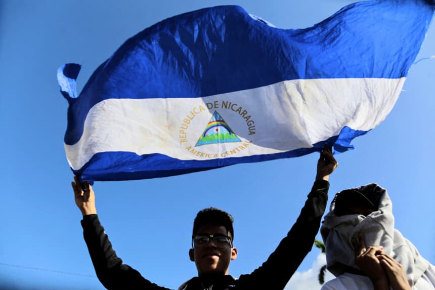 Un hombre sostiene una bandera de Nicaragua durante una misa campal celebrada por la Iglesia Católica en favor de la paz en Nicaragua, en Managua, el 1 de enero de 2019. (INTI OCON/AFP vía Getty Images)