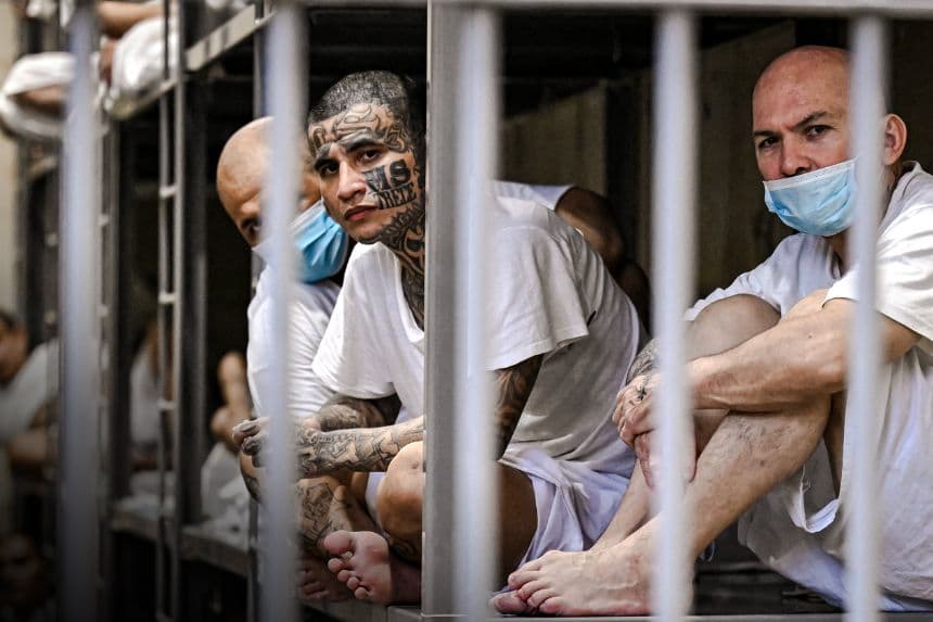 Reclusos sentados en su celda mientras el Ministro de Seguridad de Costa Rica, Gerald Campos, recorre el Centro de Reclusión contra el Terrorismo (CECOT) en Tecoluca, El Salvador, el 4 de abril de 2025. (Marvin Recinos/AFP vía Getty Images)