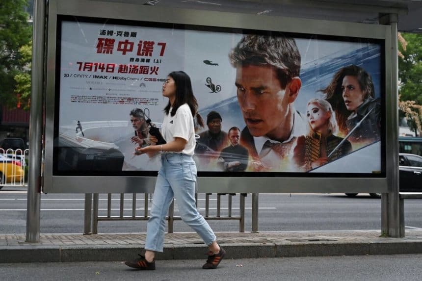 Una mujer pasa junto a un cartel de la película "Misión imposible: Repercusión mortal", en una parada de autobús de Beijing, el 21 de julio de 2023. (Greg Baker/AFP a través de Getty Images)