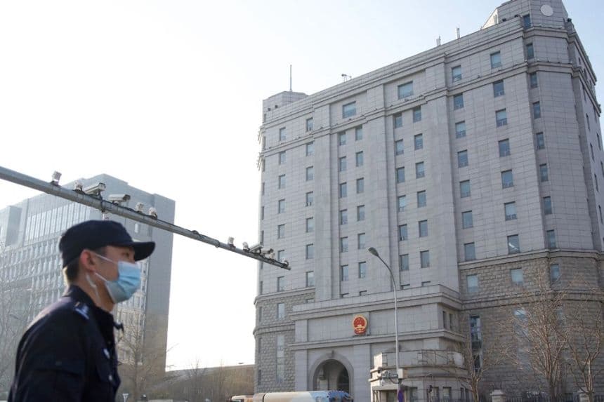 Un policía junto a una hilera de cámaras de vigilancia frente al Tribunal Popular Intermedio nº 2 de Beijing, en Beijing, el 31 de marzo de 2022. (Noel Celis/AFP vía Getty Images)