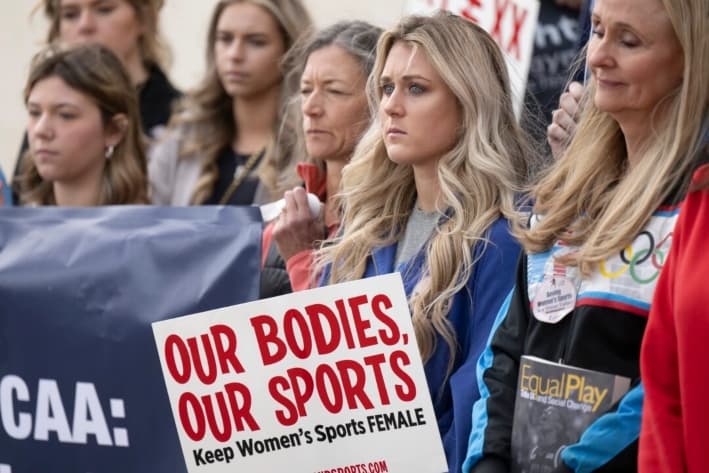 La exnadadora de la Universidad de Kentucky, Riley Gaines (2.° a la derecha), en una manifestación para proteger el deporte femenino, frente a la Convención de la NCAA, en San Antonio, el 12 de enero de 2023. (Darren Abate/Foto AP)