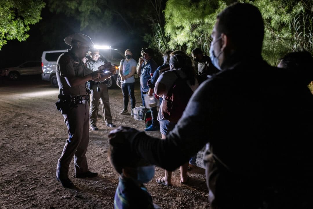 Inmigrantes ilegales procedentes de Venezuela se entregan a la policía estatal de Texas tras cruzar la frontera desde México hacia Del Río, Texas, el 18 de mayo de 2021. (John Moore/Getty Images).
