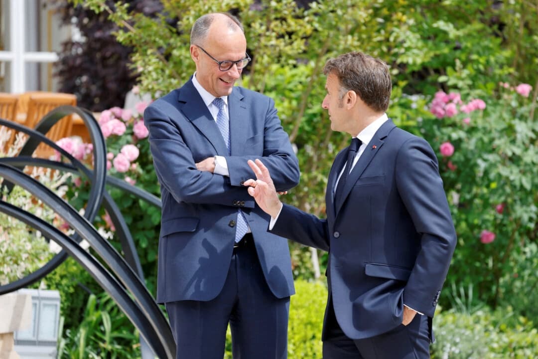 El presidente francés Emmanuel Macron (derecha) habla con el recién elegido canciller alemán, Friedrich Merz, en los jardines del palacio presidencial del Elíseo, en París, Francia, el 7 de mayo de 2025. (Ludovic Marin/ Reuters)