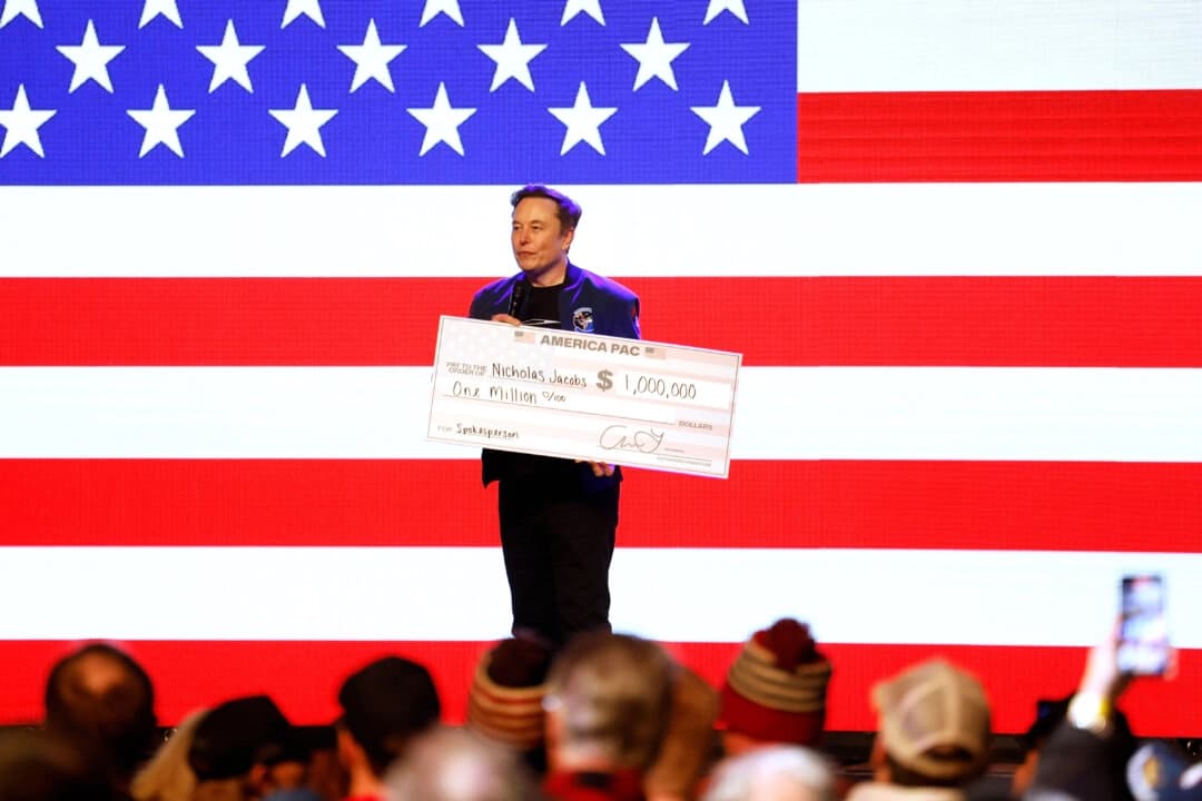 Elon Musk sostiene un cheque por valor de un millón de dólares destinado a Nicholas Jacobs, presidente de los Republicanos Universitarios de Wisconsin, en un ayuntamiento de Green Bay, Wisconsin, el 30 de marzo de 2025. (Jeffrey Phelps/AP Photo)