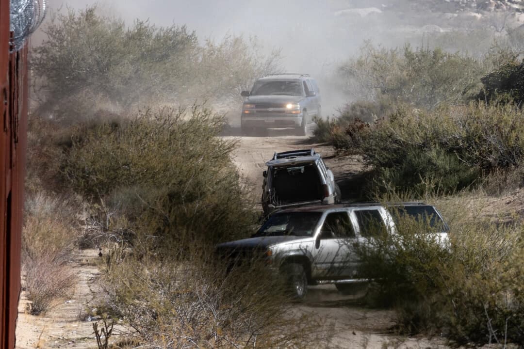 Miembros de un cártel mexicano conducen camionetas todoterreno para traficar migrantes cerca del muro fronterizo de Estados Unidos próximo a Jacumba, California, el 6 de diciembre de 2023. (John Fredricks/The Epoch Times)